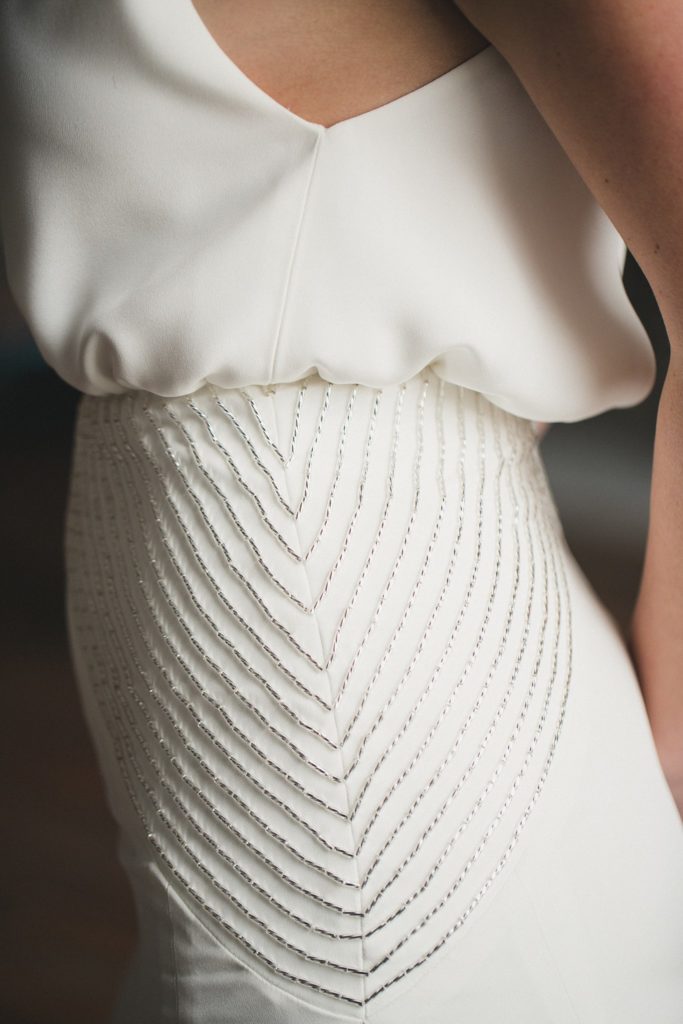 Hand sewn rows of crystal beads on the Heathe crepe wedding gown