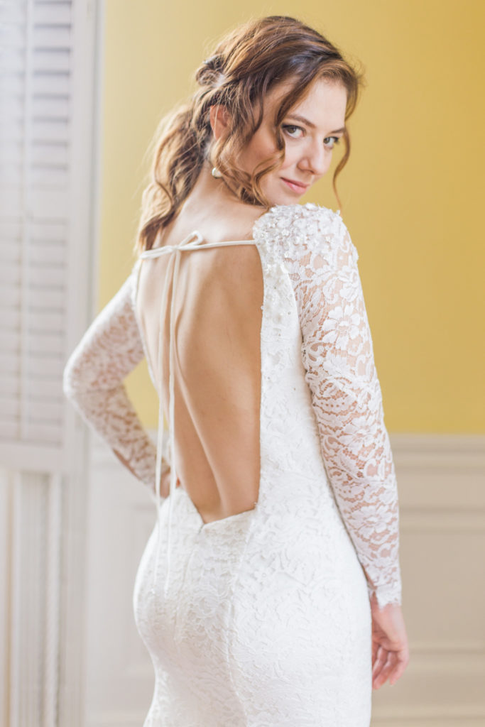 Low back lace and crepe wedding dress with 3D flower elements on the shoulders of the lace sleeves