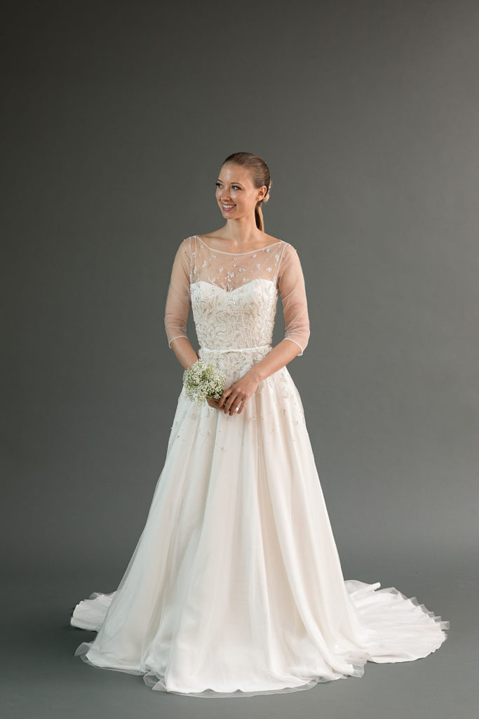 The Rei beaded a-line wedding dress features a sheer bateau neckline