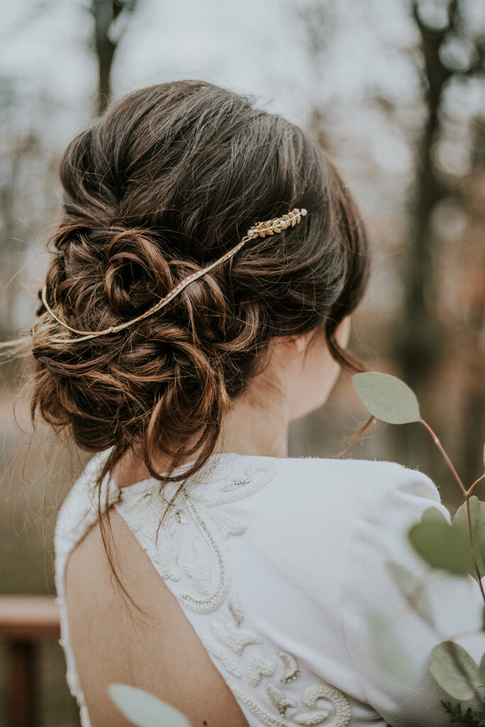 Updo hair style paired with Iman for a fall camp wedding.