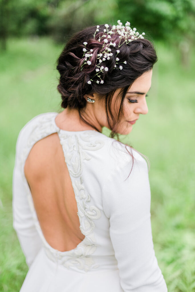 Flower updo hair style paired with Iman for an outdoor spring nature wedding.