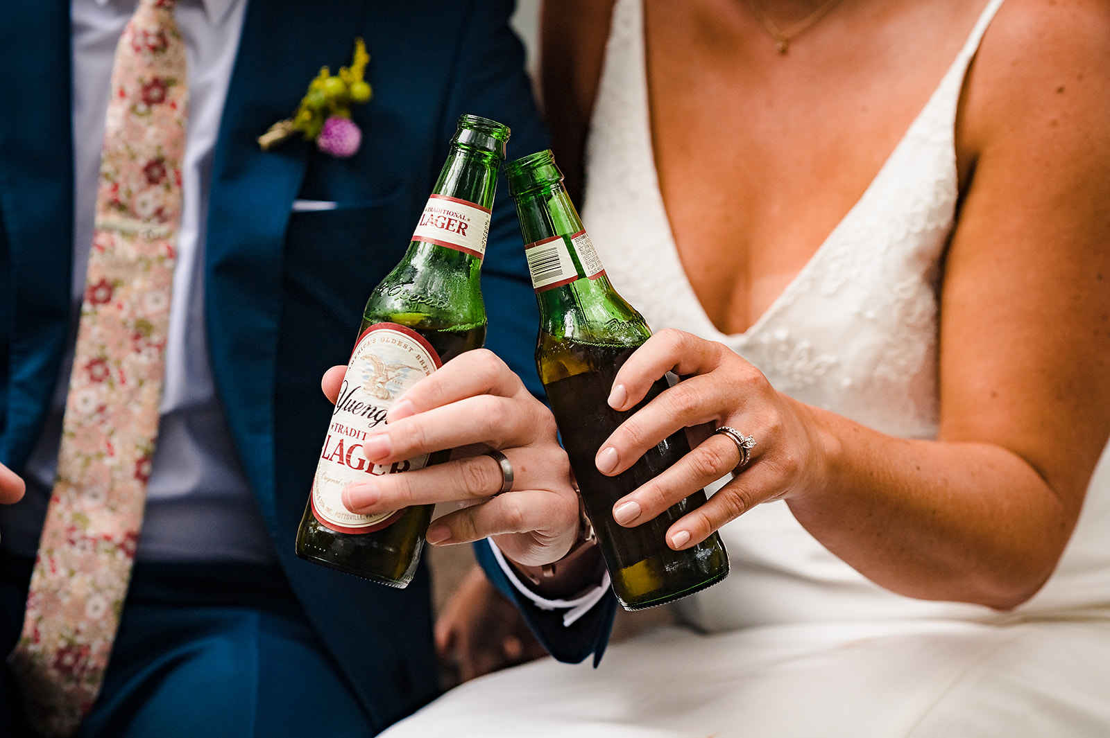 Bride and groom holding Yuengling beer bottles for a cheers