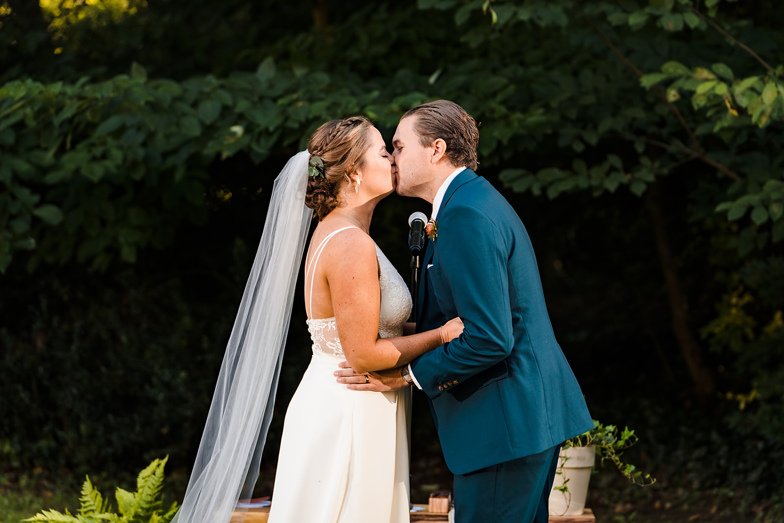 Bride and groom first kiss at end of Awbury Arboretum wedding ceremony