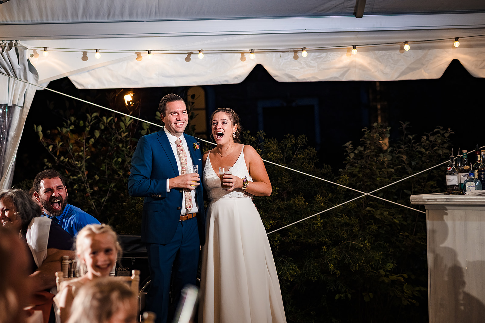 Bride and groom reacting to toasts given during reception
