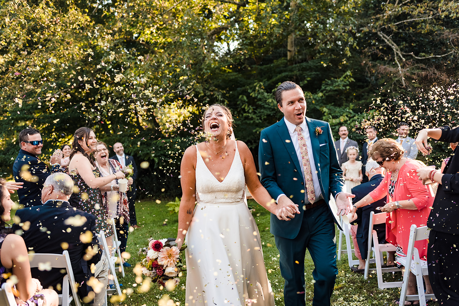 Bride and groom exit ceremony at Awbury Arboretum wedding under a shower of eco-friendly dried flower confetti