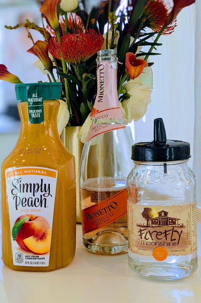 Ingredients for the Luna Bellini Cocktail by Edith Elan: peach juice, prosecco, and peach moonshine