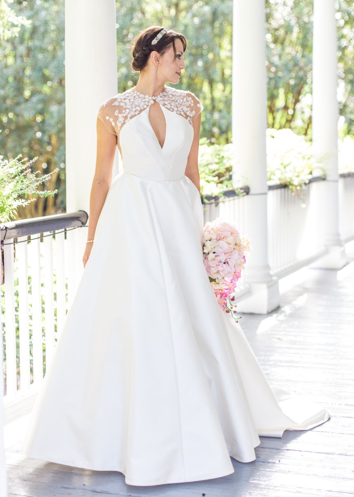 Aurora by Edith Elan is a modern ballgown wedding dress in mikado with an illusion neckline and back appliqued with 3D flowers.