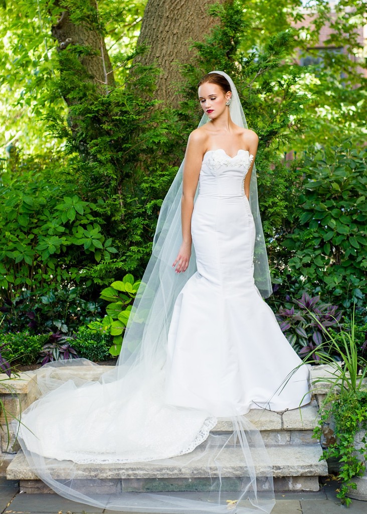 Nina is a strapless mermaid wedding dress with 3D flower details and a scalloped lace train.