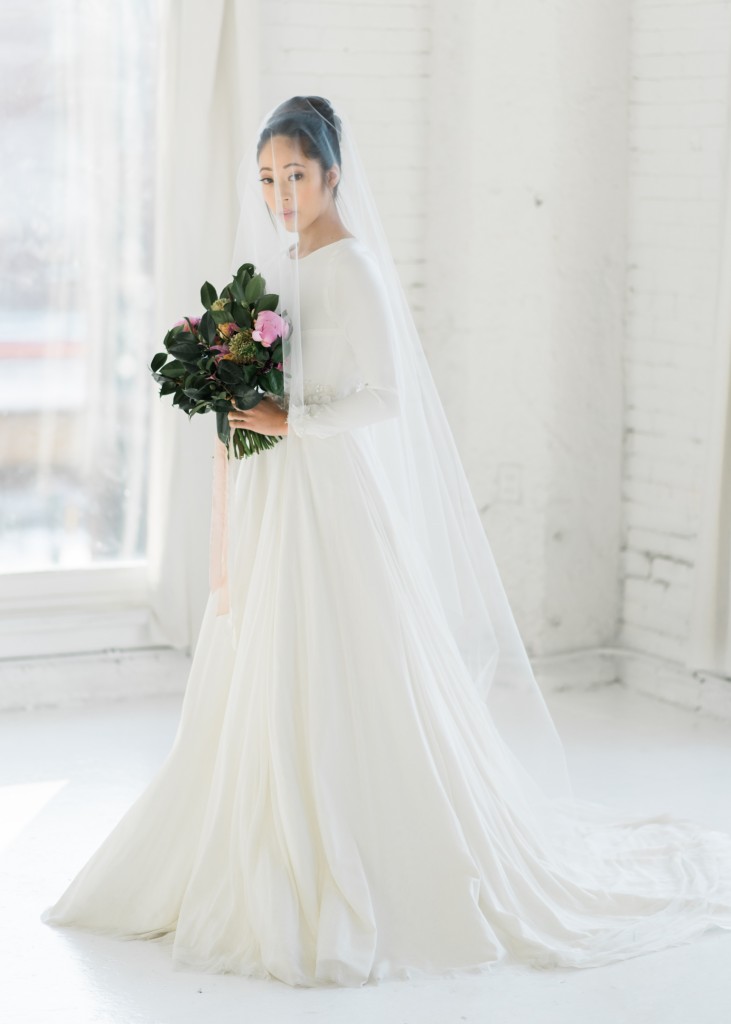 Pia is an A line wedding dress with a long sleeve silk crepe bodice and silk tulle skirt. The high neck on the front contrasts with the low open back.