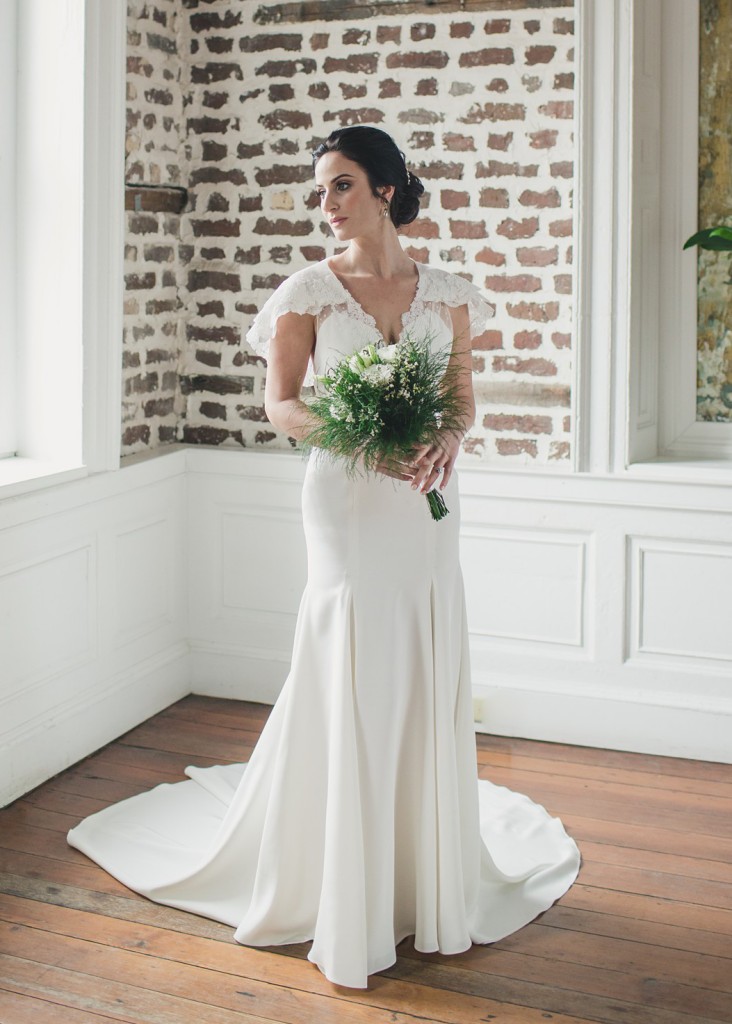 Wisteria is a silk crepe wedding gown with lace accents on the sweetheart neckline and a tiered lace capelet.