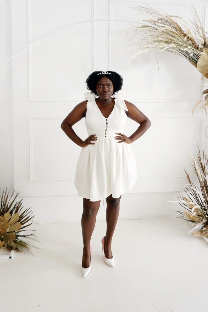 Short statement wedding dress with pearl accents and V-neck.