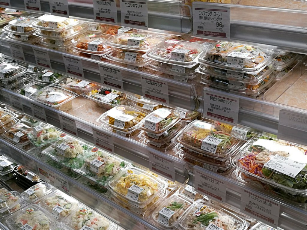 Stacks of clear plastic containers with prepared meal options at a convenience store.
