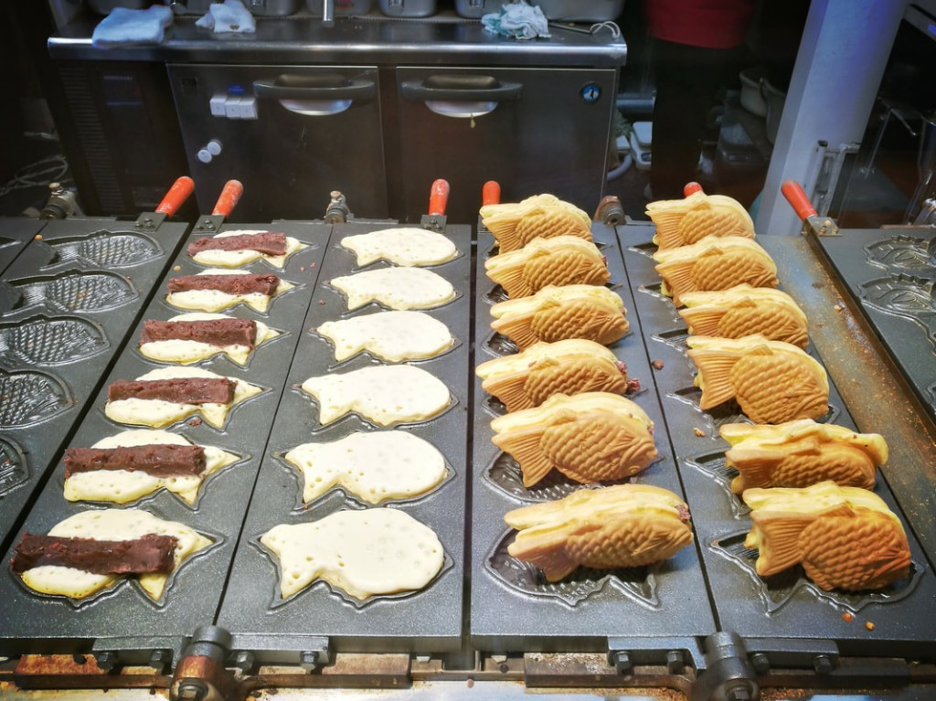 Fish-shaped street pastry cooking on a griddle that you'll find exploring Tokyo.