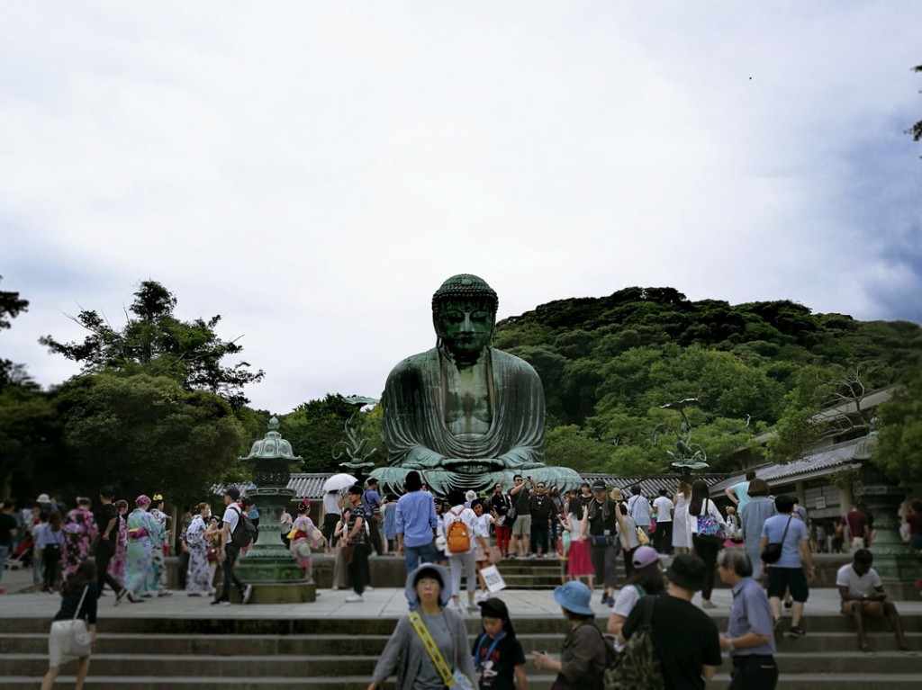 The Great Buddha statue in Kamakura amongst a sea of people.