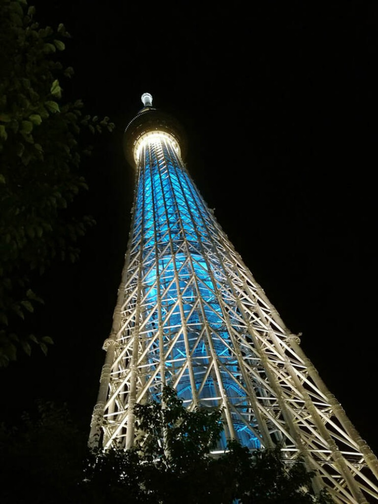 The Tokyo Skytree lit u pin blue and white at night.