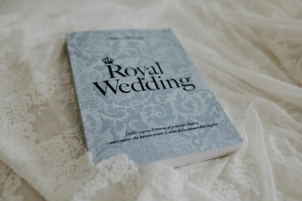 Blue book called Royal Wedding laying on a white lace fabric.