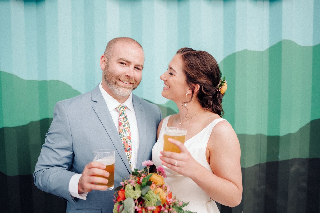 Bride and groom portrait holding beers at their Asheville brewery wedding.