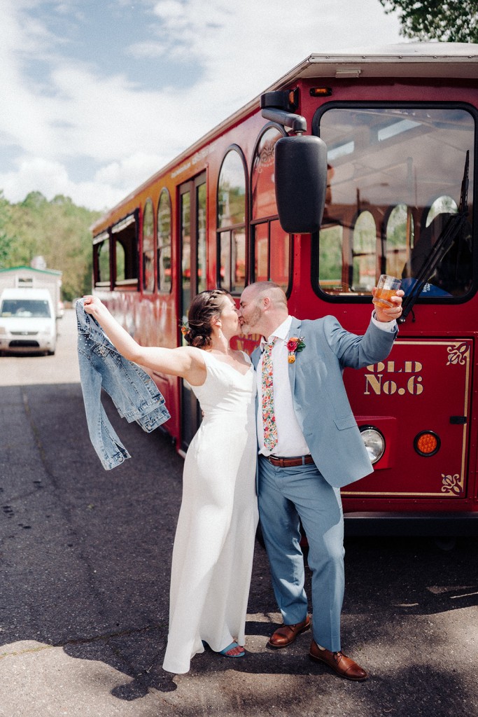Newlywed photo standing in front of a red trolley at Highland Brewing in Asheville NC