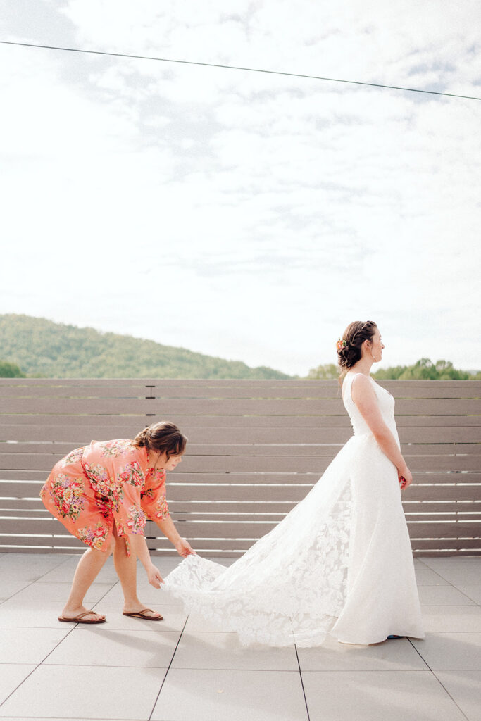 The bride's detachable lace train being fluffed for getting ready portraits