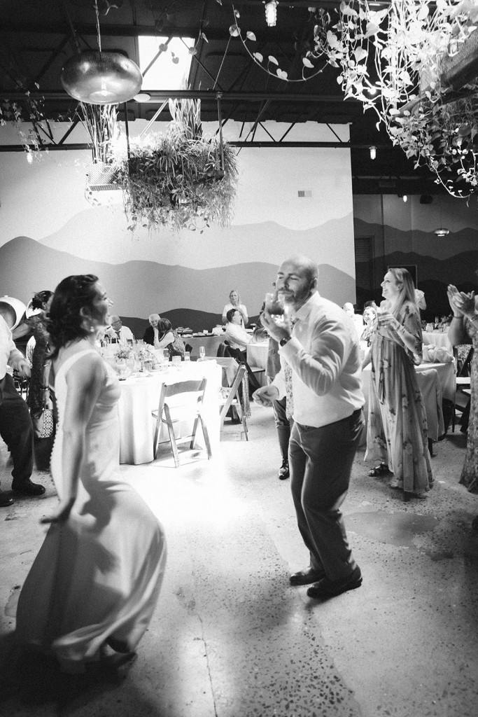 Newlyweds dancing with guests during their Asheville brewery wedding reception.
