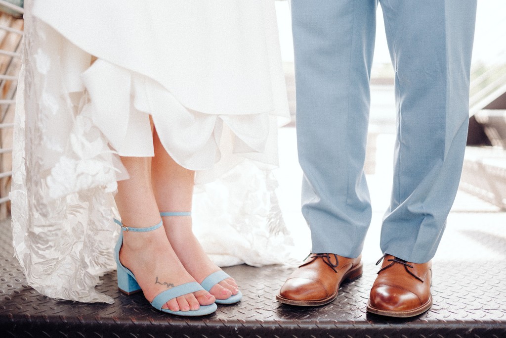 The bride and groom show off their wedding shoes