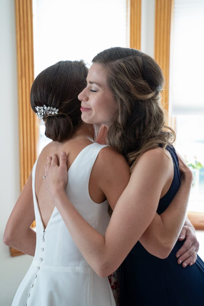 The bride hugging her sister and maid of honor
