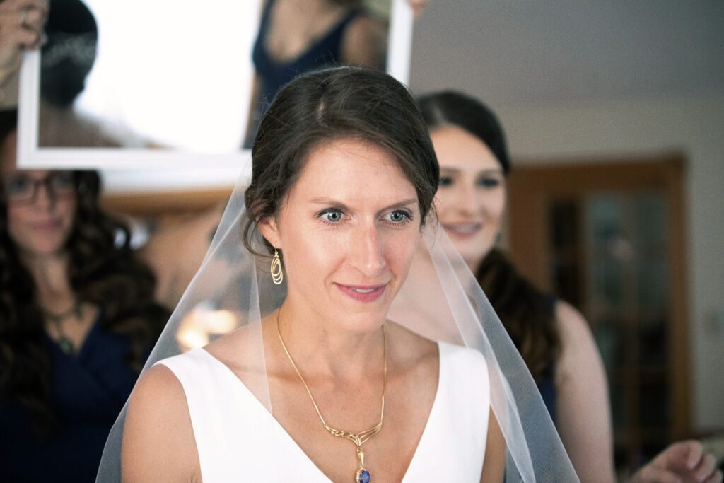 Bride looking in the mirror after putting on her accessories and jewelry