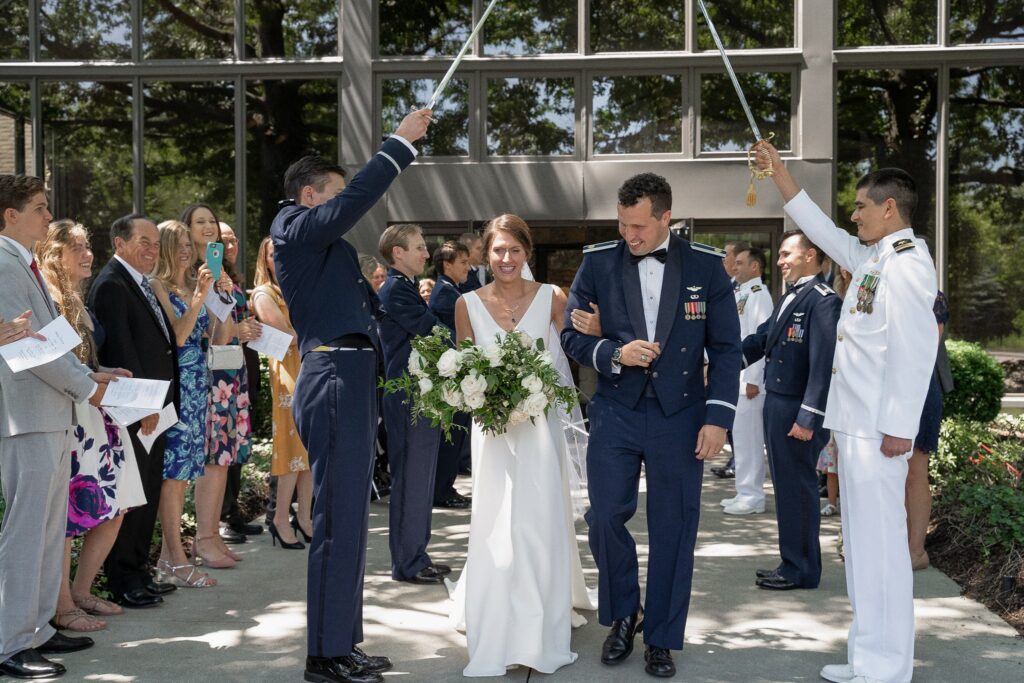 Bride and groom exiting the wedding ceremony under the military sword arch