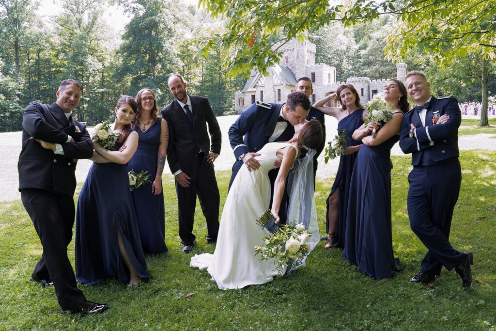 Fun wedding party portrait with the newlyweds kissing