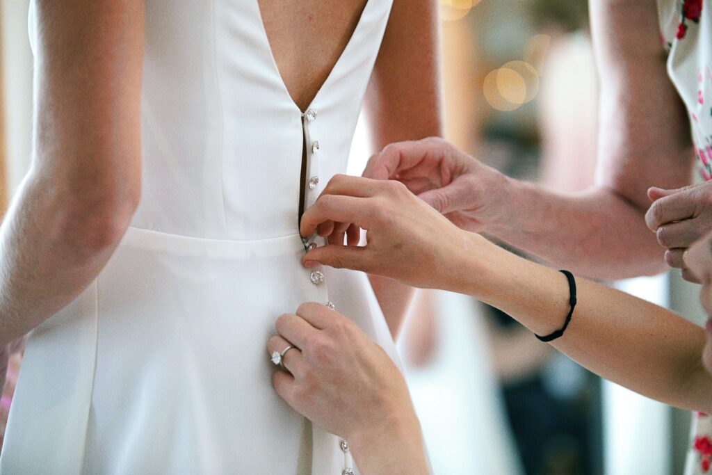Edith Élan bride getting zipped into her bespoke wedding gown
