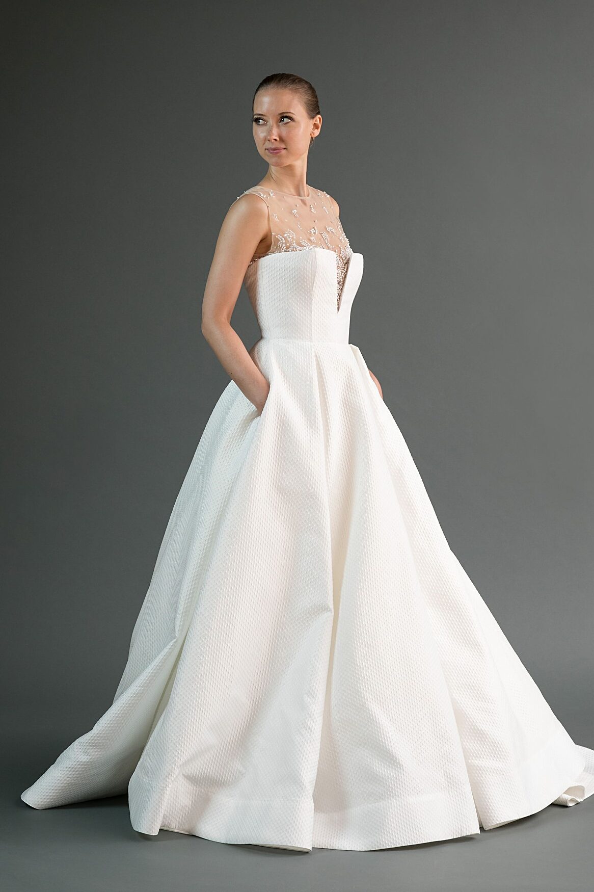 Kei is a textured wedding dress with pockets and an illusion neckline