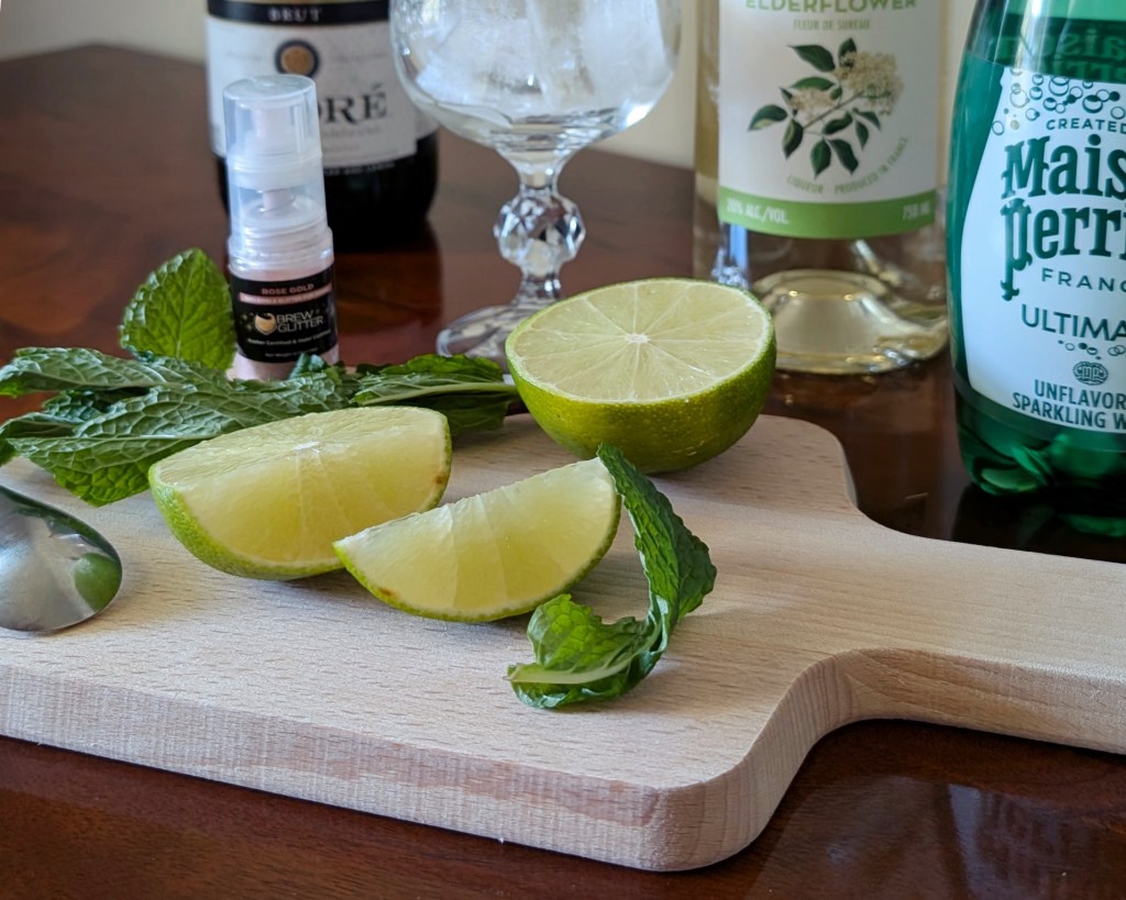 Lime and mint for a sparkling Hugo Spritz cocktail variation that includes edible glitter.