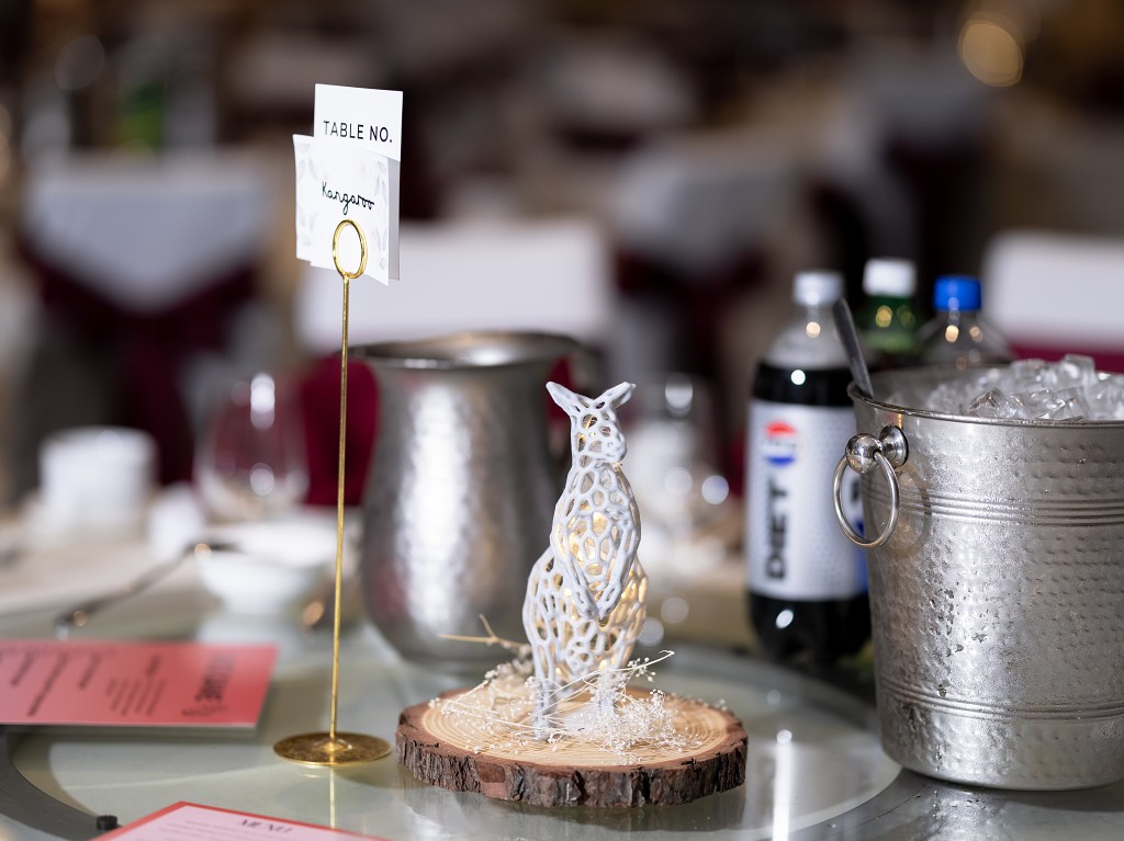 Wedding reception 3D printed animal table decor on a slice of wood.