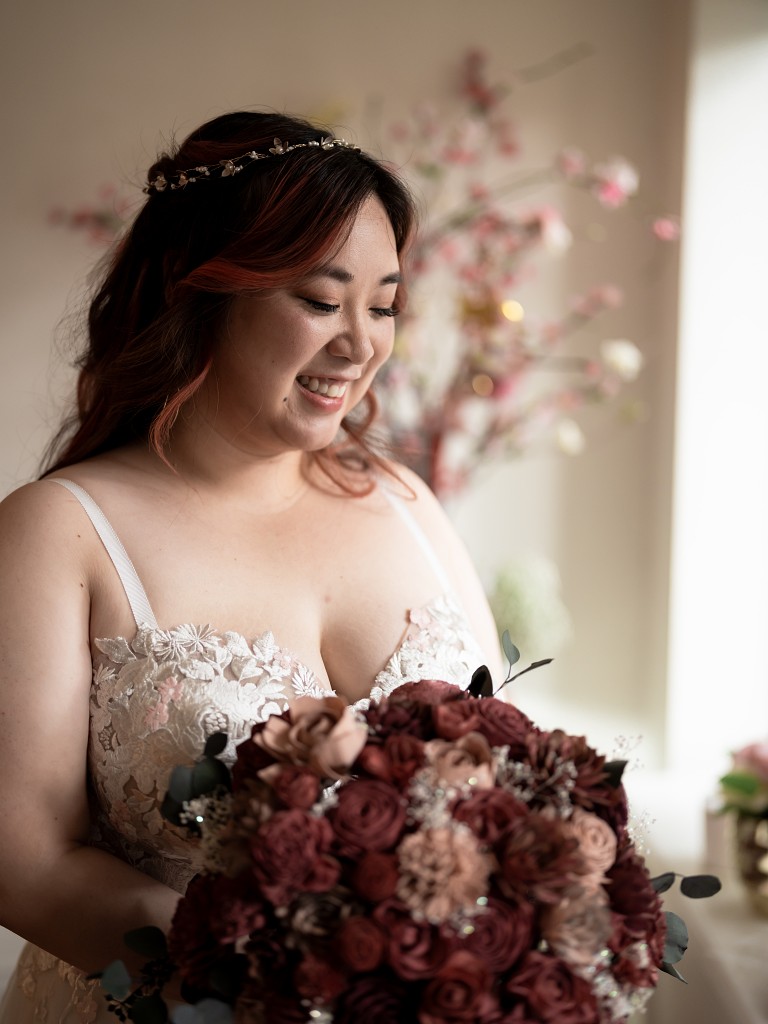 NYC bride wearing a custom blush and lace wedding dress by Edith Élan, a hair vine, and a wooden flower bouquet.