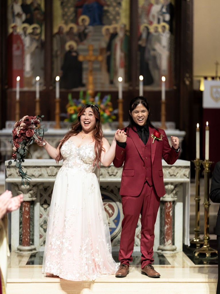 Fordham University Church wedding with bride in custom blush and lace wedding dress and groom in red suit.