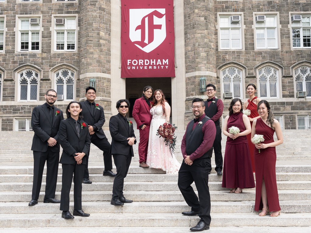 Red and black wedding bridal party on stairs at Fordham University in NYC.
