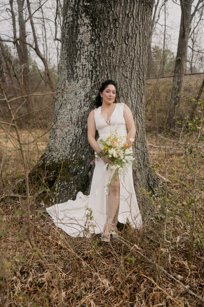 The Mariposa butterfly wedding dress by Edith Élan against a tree in the North Carolina woods.